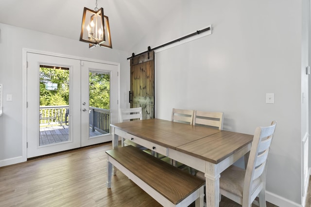168 Kentucky Ln, Pine Knot, KY 42635 - dining space featuring french doors, a barn door, wood finished floors, a chandelier, and lofted ceiling