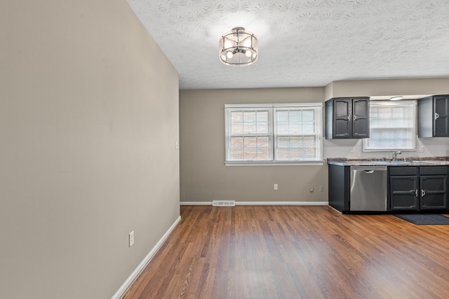 3848 Mcgarry Dr, Lexington, KY 40514 - kitchen with stainless steel dishwasher, wood finished floors, and a textured ceiling