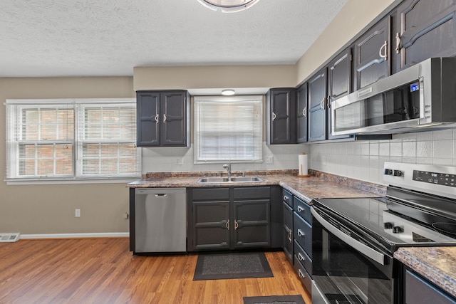 3848 Mcgarry Dr, Lexington, KY 40514 - kitchen with appliances with stainless steel finishes, light wood-style flooring, healthy amount of natural light, a textured ceiling, and tasteful backsplash