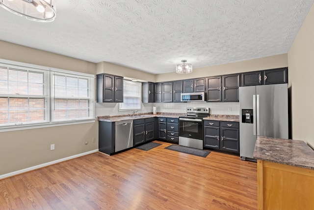 3848 Mcgarry Dr, Lexington, KY 40514 - kitchen with appliances with stainless steel finishes, a textured ceiling, and light wood finished floors