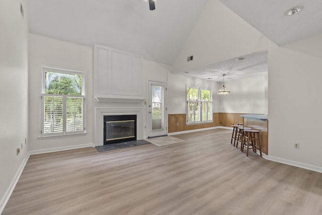 1048 Vero Ct, Lexington, KY 40509 - living area featuring a fireplace, light wood-style flooring, wainscoting, lofted ceiling, and ceiling fan