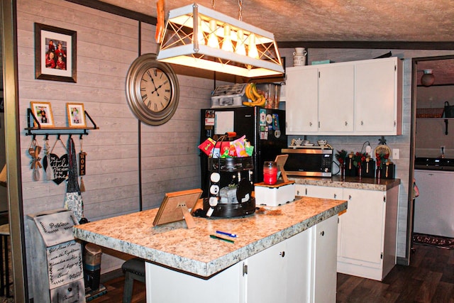 610 Freeman Branch Rd, East Bernstadt, KY 40729 - kitchen with stainless steel microwave, white cabinetry, wood walls, light countertops, and a kitchen island