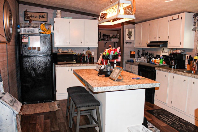 610 Freeman Branch Rd, East Bernstadt, KY 40729 - kitchen featuring freestanding refrigerator, stainless steel microwave, under cabinet range hood, white cabinetry, and dark wood-type flooring