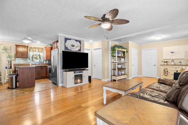 1809 Pine Top Rd, London, KY 40741 - living area with ceiling fan, light wood-style floors, a glass covered fireplace, and crown molding