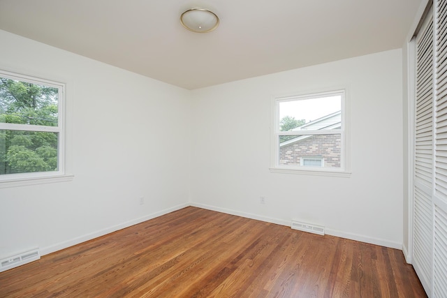 139 Tartan Dr, Lexington, KY 40517 - unfurnished bedroom featuring multiple windows, wood finished floors, and a closet