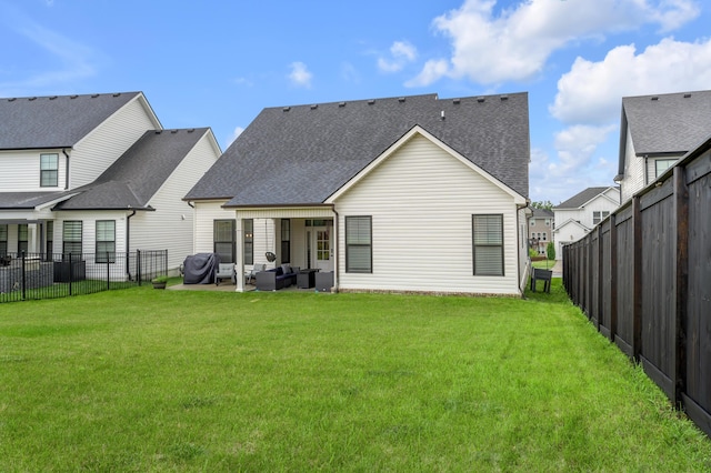 1912 Tidewater Flt, Lexington, KY 40509 - back of property with an outdoor living space, roof with shingles, a fenced backyard, and a patio area