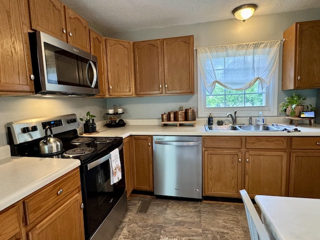 120 Lanetown Rd, Nancy, KY 42544 - kitchen featuring appliances with stainless steel finishes, a textured ceiling, light countertops, brown cabinetry, and dark stone finish flooring