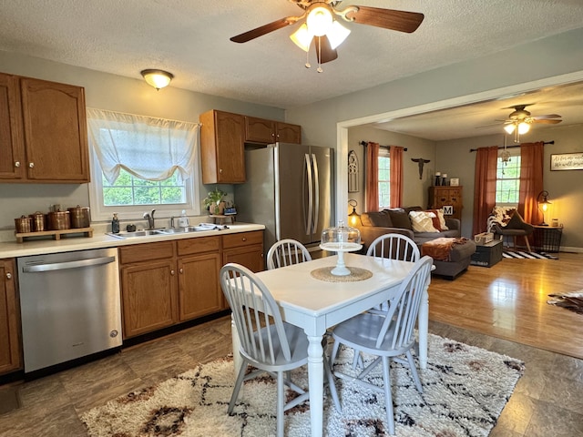 120 Lanetown Rd, Nancy, KY 42544 - kitchen featuring stainless steel appliances, ceiling fan, open floor plan, light countertops, and brown cabinetry