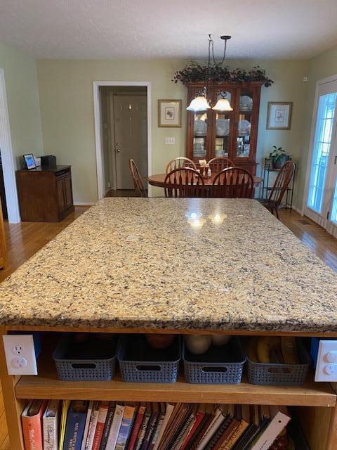 407 Autumn Dr, Lancaster, KY 40444 - kitchen featuring a kitchen island, light stone counters, wood finished floors, and hanging light fixtures