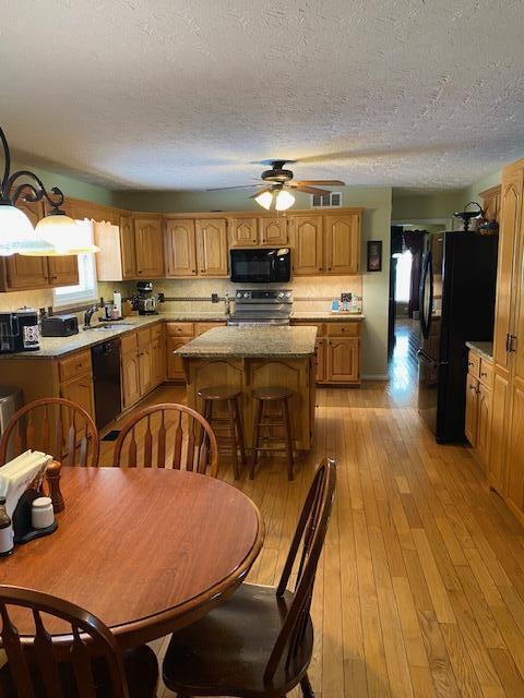 407 Autumn Dr, Lancaster, KY 40444 - dining room featuring a ceiling fan, light wood finished floors, and a textured ceiling