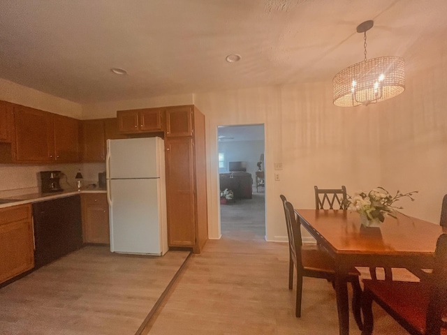 1185 Oak Ridge Rd, Corbin, KY 40701 - kitchen featuring freestanding refrigerator, a chandelier, light wood-style floors, pendant lighting, and light countertops