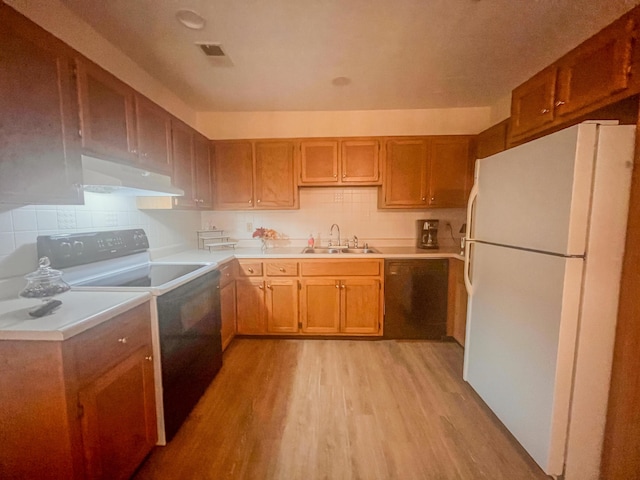 1185 Oak Ridge Rd, Corbin, KY 40701 - kitchen featuring freestanding refrigerator, stove, exhaust hood, black dishwasher, and light wood-type flooring