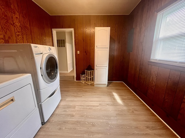 1185 Oak Ridge Rd, Corbin, KY 40701 - laundry room with washing machine and dryer, wooden walls, light wood finished floors, and plenty of natural light