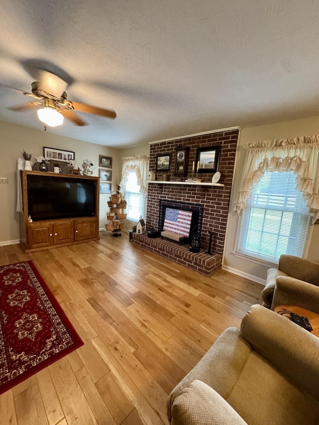 4295 Vince Rd, Nicholasville, KY 40356 - living room featuring a brick fireplace, hardwood / wood-style floors, a textured ceiling, and a ceiling fan