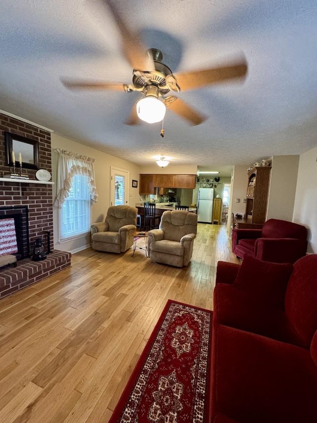 4295 Vince Rd, Nicholasville, KY 40356 - living room featuring a textured ceiling, ceiling fan, light wood-style flooring, and a fireplace