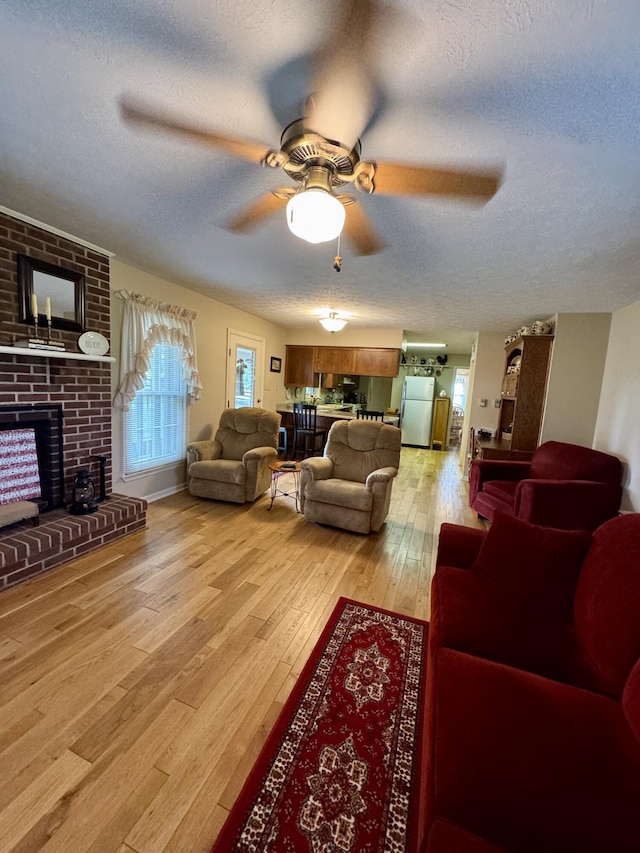 4295 Vince Rd, Nicholasville, KY 40356 - living room with a textured ceiling, ceiling fan, light wood finished floors, and a fireplace