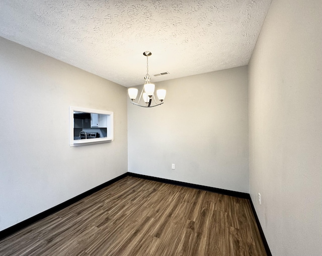 404 Bainbridge Ct Unit E3, Lexington, KY 40509 - spare room with dark wood-style flooring, a chandelier, and a textured ceiling