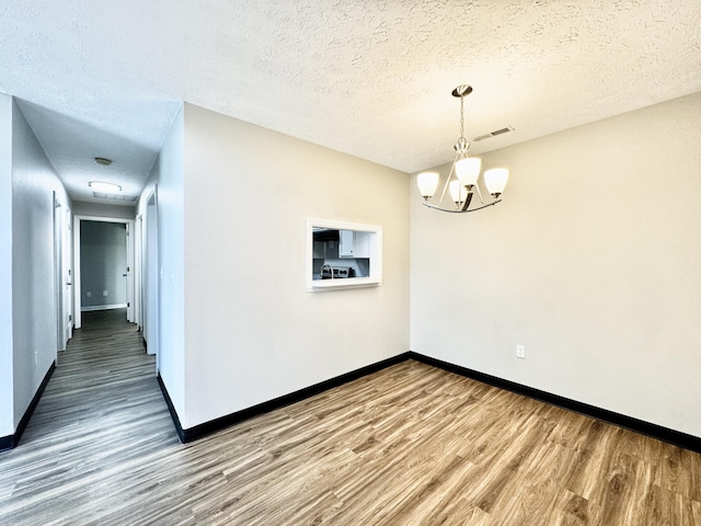 404 Bainbridge Ct Unit E3, Lexington, KY 40509 - empty room with wood finished floors, a chandelier, and a textured ceiling