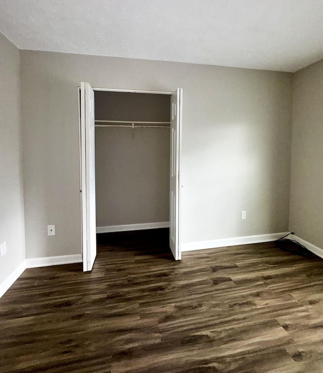 404 Bainbridge Ct Unit E3, Lexington, KY 40509 - unfurnished bedroom featuring dark wood-style flooring and a closet