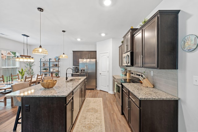 137 Kirkstall Way, Georgetown, KY 40324 - kitchen with stainless steel appliances, a breakfast bar, light wood finished floors, dark brown cabinetry, and decorative backsplash