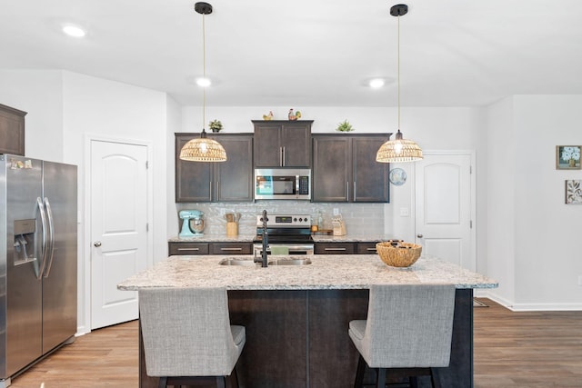 137 Kirkstall Way, Georgetown, KY 40324 - kitchen featuring stainless steel appliances, wood finished floors, dark brown cabinetry, decorative backsplash, and recessed lighting