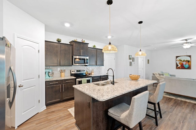 137 Kirkstall Way, Georgetown, KY 40324 - kitchen featuring stainless steel appliances, open floor plan, dark brown cabinetry, tasteful backsplash, and a breakfast bar