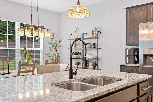 137 Kirkstall Way, Georgetown, KY 40324 - kitchen with stainless steel refrigerator with ice dispenser, light stone counters, pendant lighting, dark brown cabinetry, and a chandelier