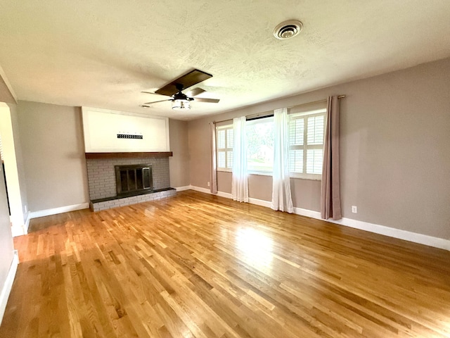 123 Hillandale Dr, Somerset, KY 42501 - unfurnished living room featuring a ceiling fan, light wood finished floors, a fireplace, and a textured ceiling