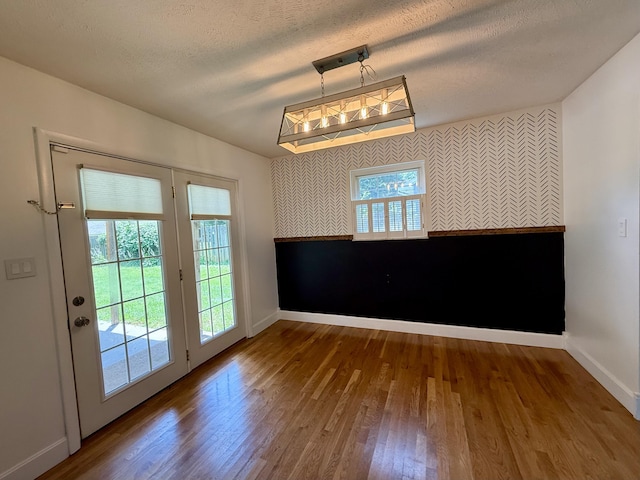 123 Hillandale Dr, Somerset, KY 42501 - unfurnished dining area featuring wood finished floors, an accent wall, wallpapered walls, and a textured ceiling