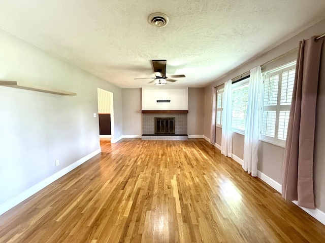 123 Hillandale Dr, Somerset, KY 42501 - unfurnished living room featuring a ceiling fan, light wood finished floors, a fireplace, and a textured ceiling