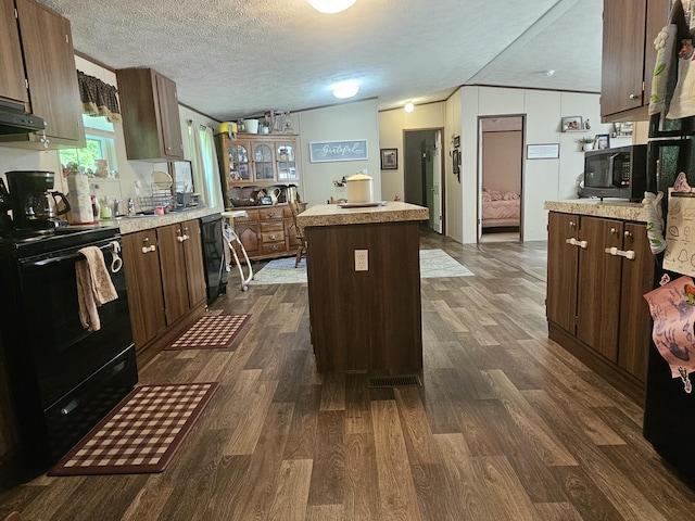 421 Dry Branch Rd, Morehead, KY 40351 - kitchen with black appliances, a kitchen island, dark wood-style flooring, light countertops, and a textured ceiling