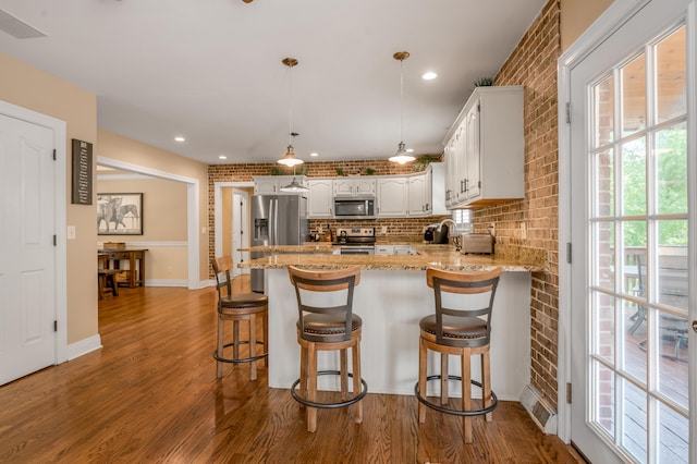 2609 Idlewood Dr, Lexington, KY 40513 - kitchen with stainless steel appliances, a peninsula, wood finished floors, white cabinetry, and light stone counters