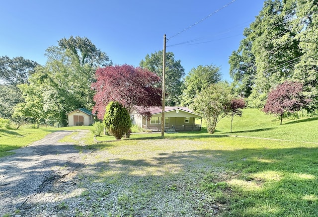 21 Herb Neal Rd, Pine Knot, KY 42635 - view of green lawn featuring a garage, an outdoor structure, and gravel driveway