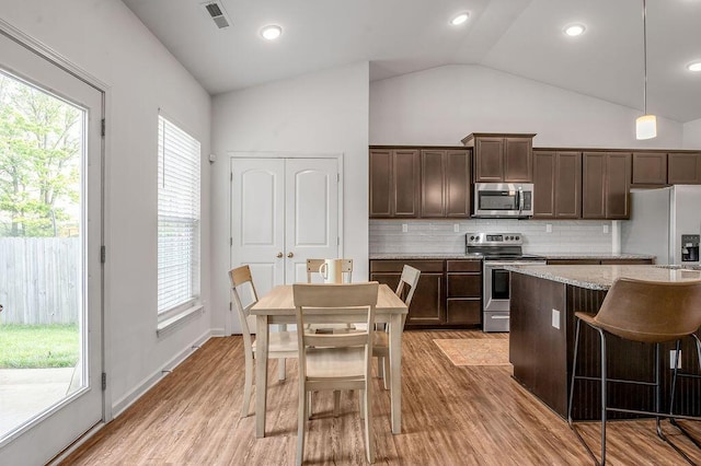 117 Mcafee Dr, Nicholasville, KY 40356 - kitchen with appliances with stainless steel finishes, vaulted ceiling, dark brown cabinets, decorative backsplash, and light wood finished floors