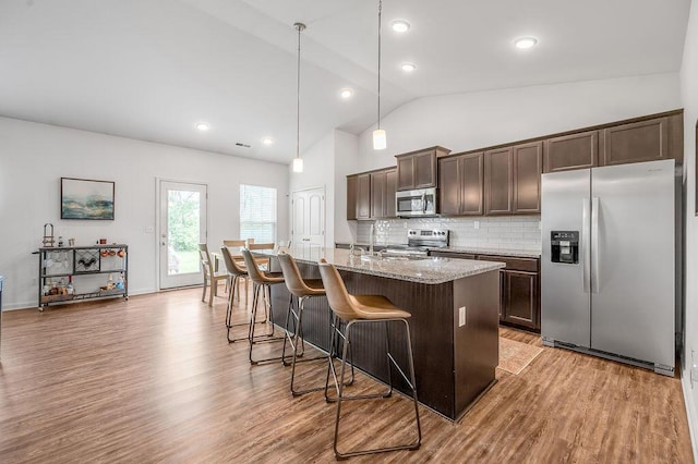 117 Mcafee Dr, Nicholasville, KY 40356 - kitchen featuring appliances with stainless steel finishes, dark brown cabinetry, decorative backsplash, a kitchen bar, and light wood-style flooring