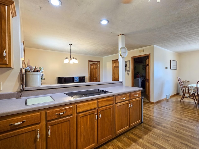 1445 Bastin Creek Rd, Kings Mountain, KY 40442 - kitchen featuring black electric cooktop, brown cabinets, crown molding, dark wood-type flooring, and a chandelier