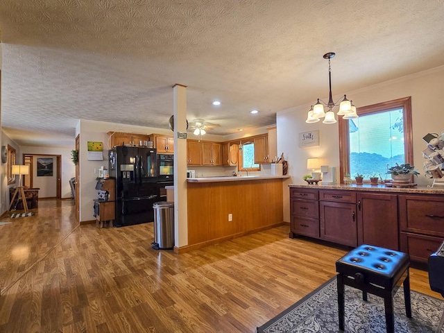 1445 Bastin Creek Rd, Kings Mountain, KY 40442 - kitchen with black fridge with ice dispenser, a peninsula, plenty of natural light, light wood-style flooring, and a textured ceiling