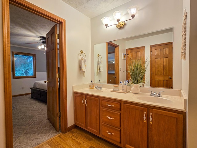 1445 Bastin Creek Rd, Kings Mountain, KY 40442 - bathroom with connected bathroom, double vanity, wood finished floors, a ceiling fan, and a textured ceiling