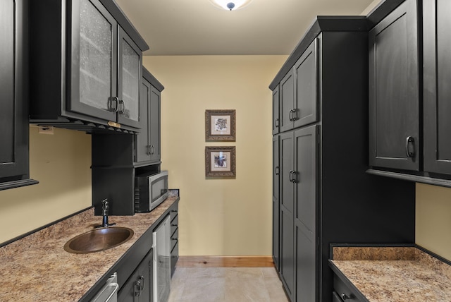 4111 Stanford Rd, Danville, KY 40422 - kitchen with stainless steel microwave, dark cabinets, light stone counters, and light tile patterned floors