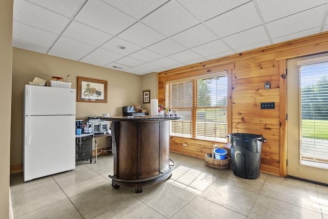 4111 Stanford Rd, Danville, KY 40422 - kitchen featuring freestanding refrigerator, light tile patterned floors, wooden walls, a drop ceiling, and dark countertops