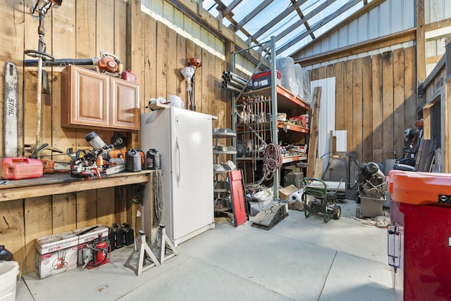 4111 Stanford Rd, Danville, KY 40422 - garage with freestanding refrigerator, wood walls, and a workshop area