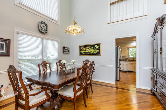 4129 Amberwood Ct, Lexington, KY 40513 - dining area with a chandelier, a high ceiling, and light wood-style floors