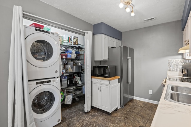 1008 Marshall Park Dr, Georgetown, KY 40324 - laundry room featuring stacked washer and clothes dryer and a textured ceiling