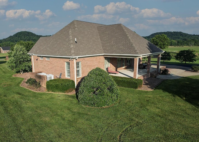 168 Master Ct, Hustonville, KY 40437 - view of property exterior with a patio area, brick siding, a yard, and roof with shingles