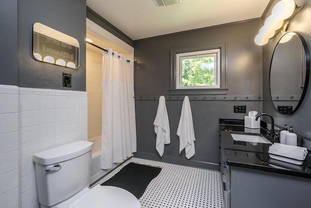 321 Center St, Berea, KY 40403 - bathroom featuring tile patterned floors, vanity, shower / bath combo with shower curtain, a wainscoted wall, and tile walls