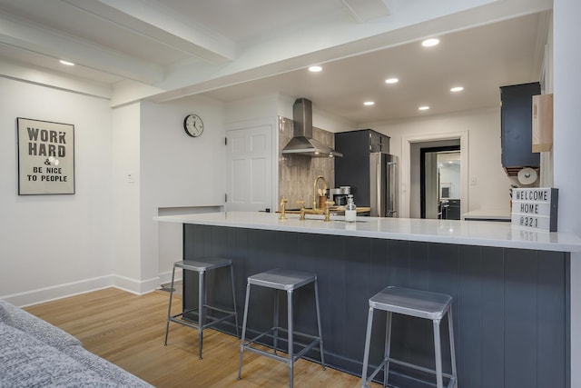 321 Center St, Berea, KY 40403 - kitchen featuring extractor fan, light wood finished floors, light countertops, a kitchen breakfast bar, and recessed lighting