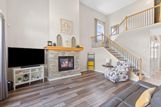 115 Westwoods Dr, Georgetown, KY 40324 - living area featuring stairs, a stone fireplace, wood finished floors, and a towering ceiling