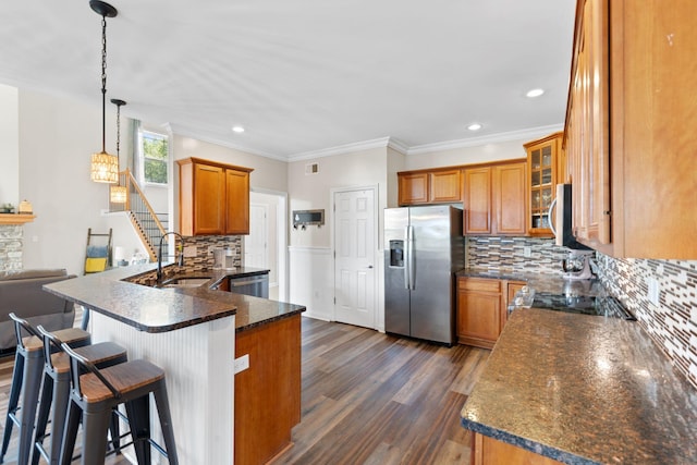 115 Westwoods Dr, Georgetown, KY 40324 - kitchen featuring stainless steel appliances, brown cabinetry, dark wood-style flooring, tasteful backsplash, and a peninsula