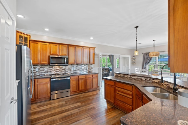 115 Westwoods Dr, Georgetown, KY 40324 - kitchen with stainless steel appliances, plenty of natural light, wood finished floors, brown cabinetry, and recessed lighting