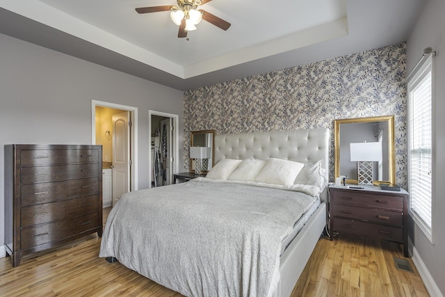3224 Orchard Grass Rd, Lexington, KY 40509 - bedroom featuring wallpapered walls, multiple windows, light wood finished floors, an accent wall, and a ceiling fan